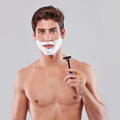 Buy stock photo Studio shot of a handsome bare chested young man shaving