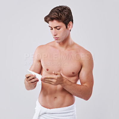 Buy stock photo Man, lotion and skincare with cream for hygiene, grooming or SPF on a gray studio background. Handsome, muscular or young male person or model with moisturizer, creme or cosmetics on mockup space