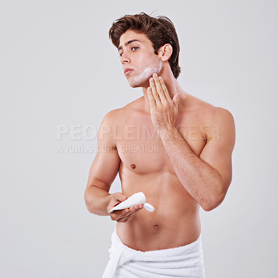 Buy stock photo Man, skincare and grooming with face cream in hygiene, SPF or facial on a gray studio background. Handsome, muscular or young male person or model with moisturizer, creme or cosmetics on mockup space