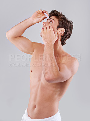 Buy stock photo Man, allergies and hygiene with eye drops for sight, vision or care on a gray studio background. Male person or young model with pharmaceutical in optical treatment, dry pupil or iris on mockup space