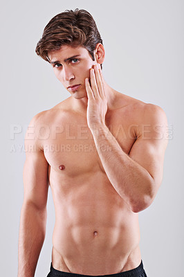 Buy stock photo Man, skincare and topless in studio portrait with hand on face for wellness by gray background. Person, model and facial dermatology for self care, health or transformation for glow, touch or results