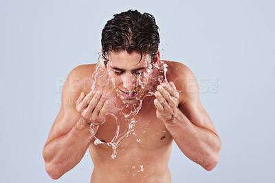 Buy stock photo Water, washing face and man on gray background for wellness, skincare and cleaning in studio. Dermatology, bathroom and person with splash, liquid and shower for hygiene, grooming and hydration
