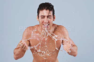 Buy stock photo Water splash, washing face and man on blue background for shower, wellness and skincare in studio. Dermatology, bathroom and person with facial, liquid or cleaning for hygiene, grooming and hydration