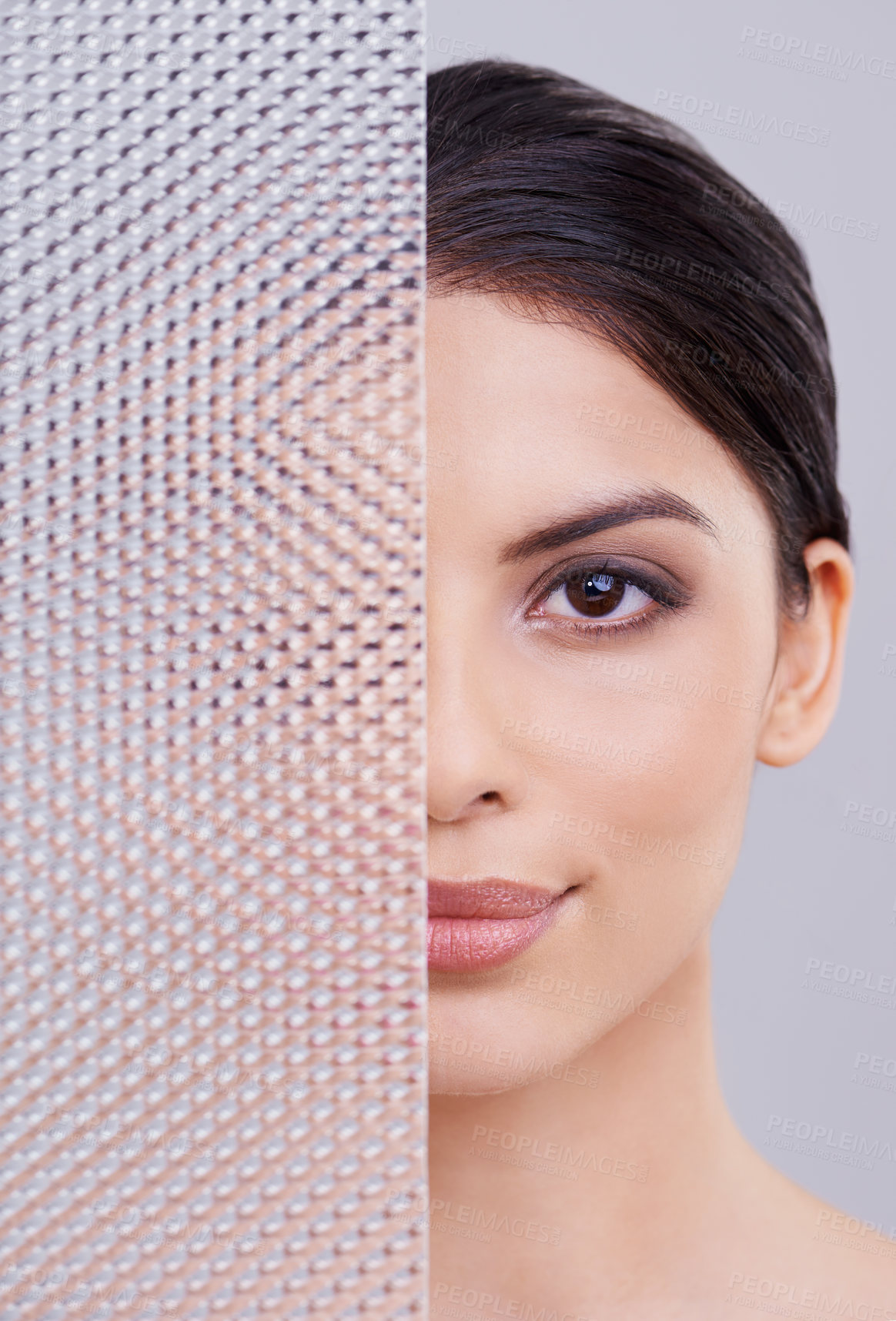 Buy stock photo Shot of a beautiful young woman with her face partially obscured through a plastic panel