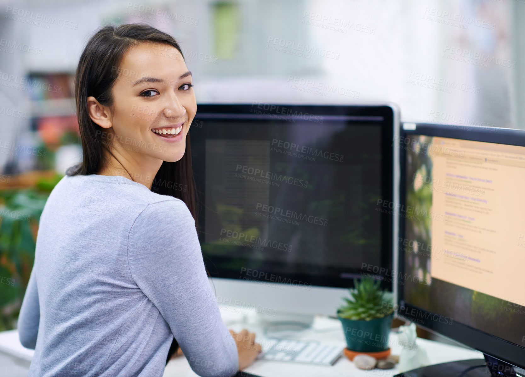 Buy stock photo Shot of an attractive young woman sitting at her workstation in the office