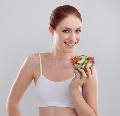 Buy stock photo Cropped shot of a sporty young woman in the studio with a salad