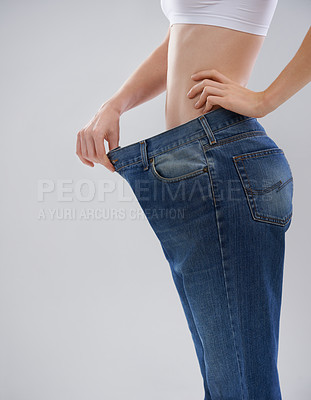 Buy stock photo Cropped shot of a woman showing off her weightloss with a large pair of trousers