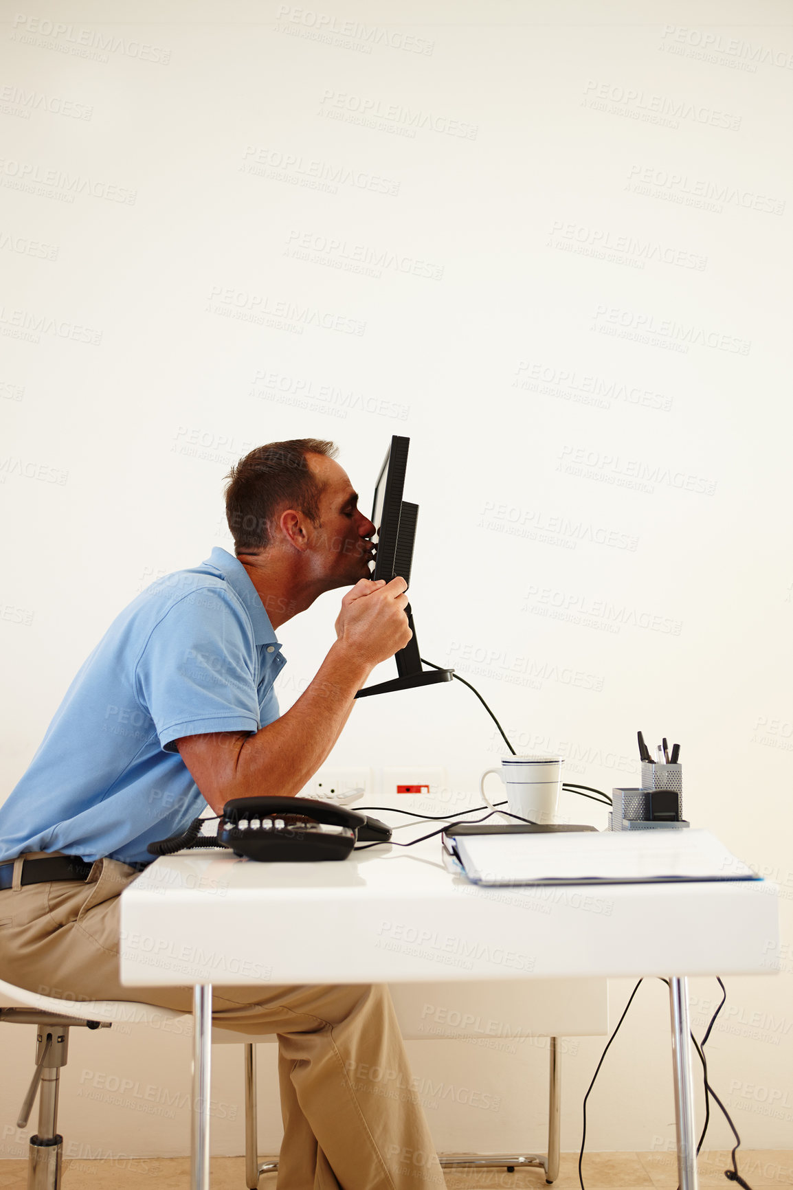 Buy stock photo A middle-aged man ethusiastically kissing his computer screen while sitting at his desk