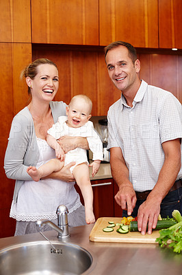 Buy stock photo Portrait, family and people in kitchen for love, happiness and bonding at home, house and apartment together. Man, woman and baby with vegetables for salad, nutrition and wellness with smile or laugh