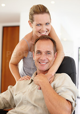 Buy stock photo Care, portrait and couple in hug on chair, love and proud of marriage milestone in home. Happy, embrace and people for relationship achievement, romance and bonding in apartment for commitment