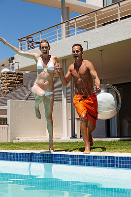 Buy stock photo Couple, woman and man jump in pool with smile, happiness and energy for swimming in water. Summer, girl and male person in resort or hotel for vacation for honeymoon, love and holiday in Cancun