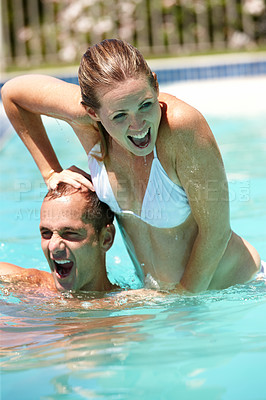 Buy stock photo Couple, swimming pool and playful in summer, laugh and excited for funny game in sunshine on vacation. Man, woman and water for comic fight, happy and push outdoor for holiday with love in Naples