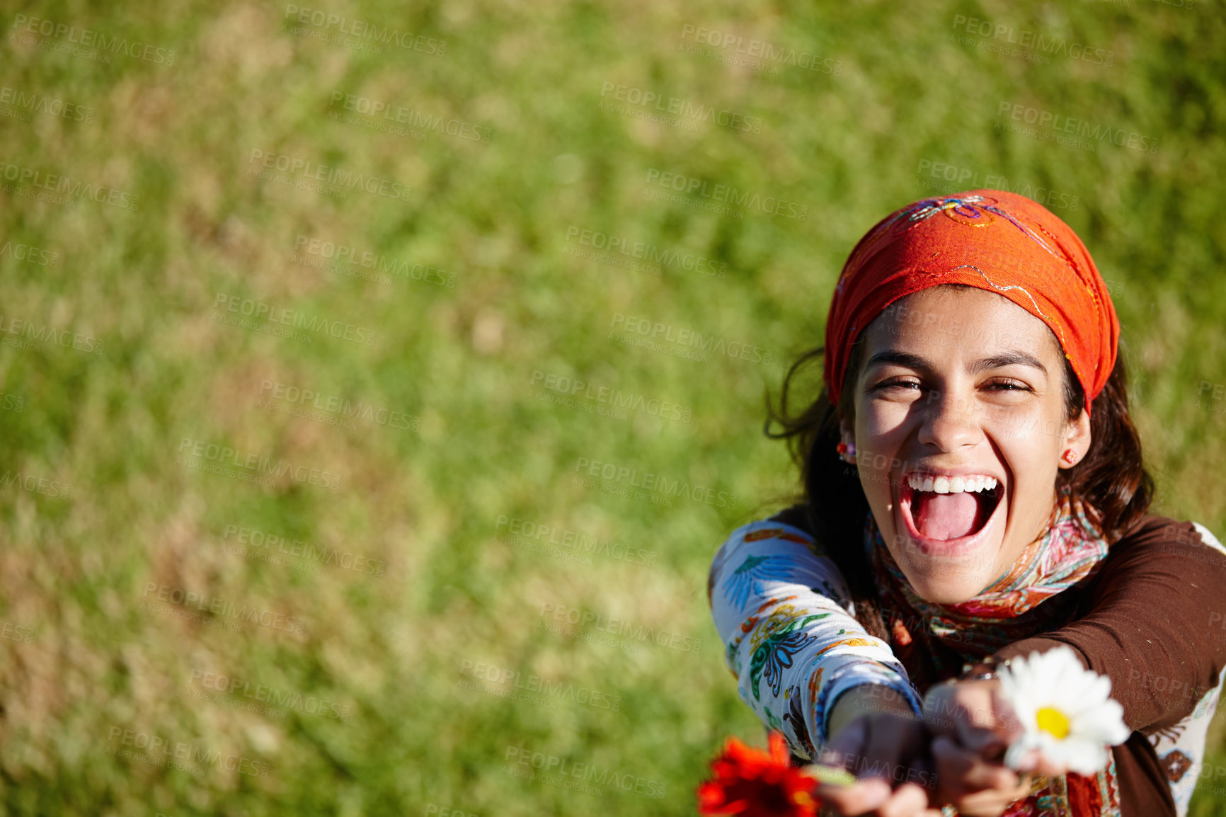 Buy stock photo Woman, laugh and portrait for gypsy with flower in nature for summer, outdoor and adventure on grass. Young person, excited and bohemian style with plant for happiness, joy and carefree on mockup 