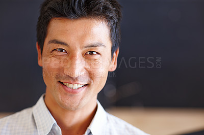 Buy stock photo Portrait of a confident Asian businessman face smiling while standing alone in a modern office. An intelligent entrepreneur looking cheerful and positive in a corporate startup corporate business 