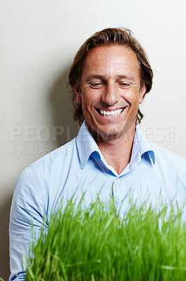Buy stock photo Businessman, smile and nature with grass in office for ecology, climate and environment. Male person, clean energy and corporate with plant by background for turf, sustainability and eco friendly