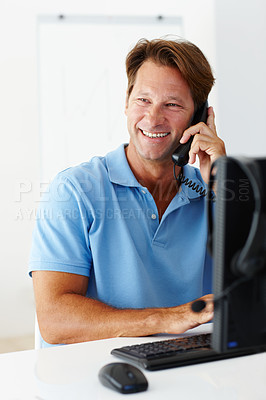Buy stock photo Happy man and telephone on computer, phone call and conversation for remote work or startup at home. Smile,  male person and freelancer or entrepreneur on smartphone for disscussion at house