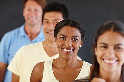 Buy stock photo Portrait of an attractive african woman standing in a line with her peers out of focus