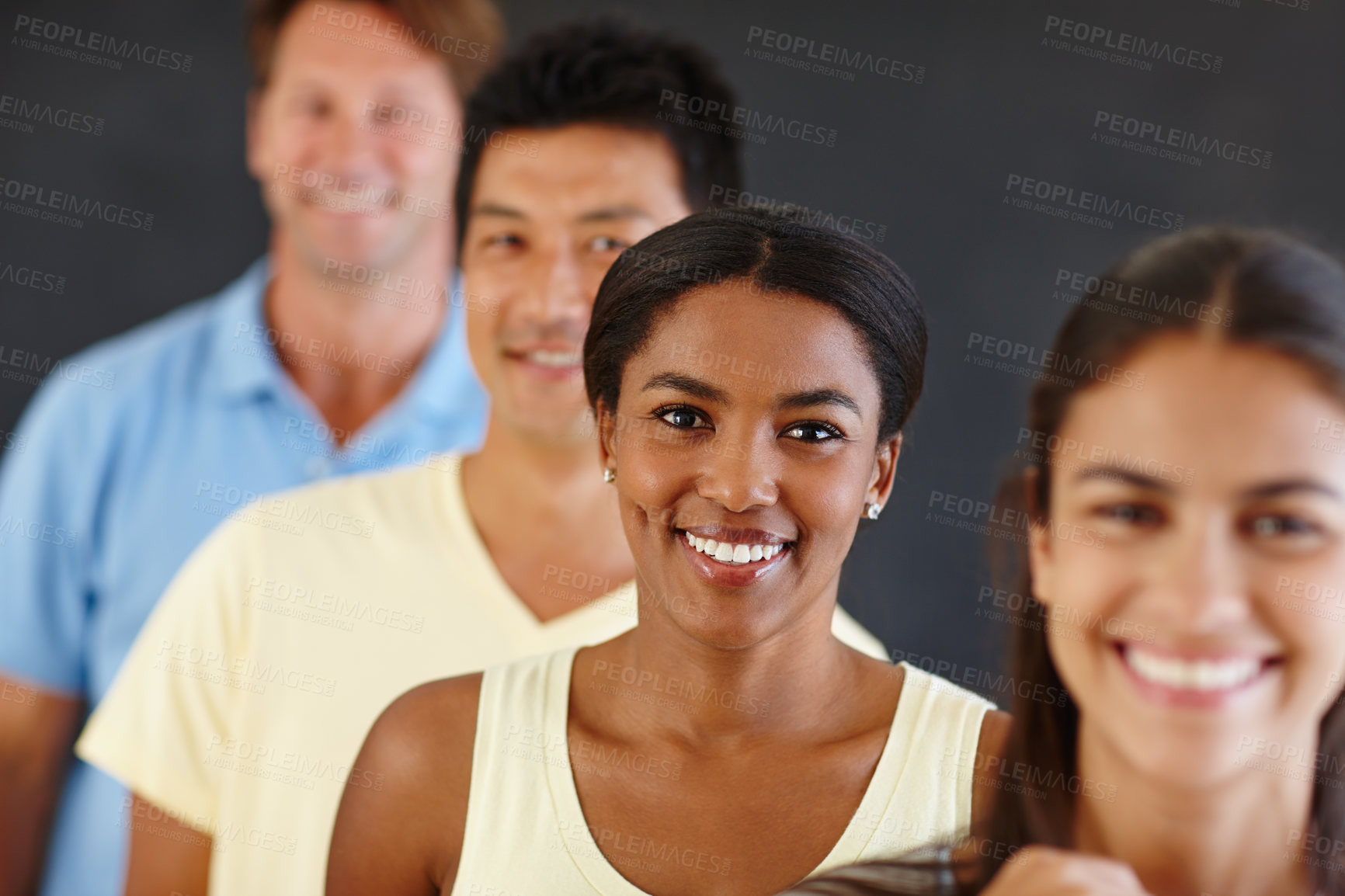 Buy stock photo Portrait of an attractive african woman standing in a line with her peers out of focus