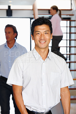 Buy stock photo Portrait, man and happy in creative team, worker in office workplace. Smile, professional and Asian male person in business, confident with staff for collaboration in company together in workspace