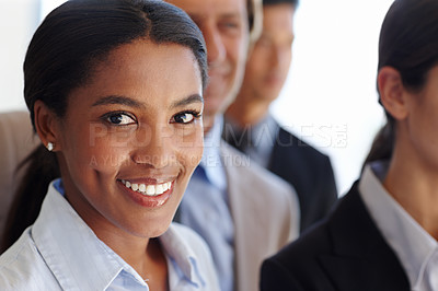 Buy stock photo Portrait of a young businesswoman smiling with her coworkers in the background. Portrait of a happy smiling successful respectable proud businesswoman and team leader. 
