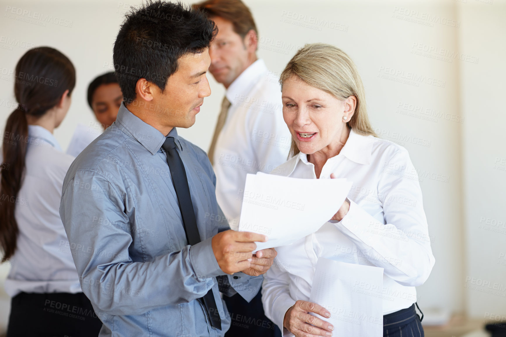 Buy stock photo Two business professionals discussing a document