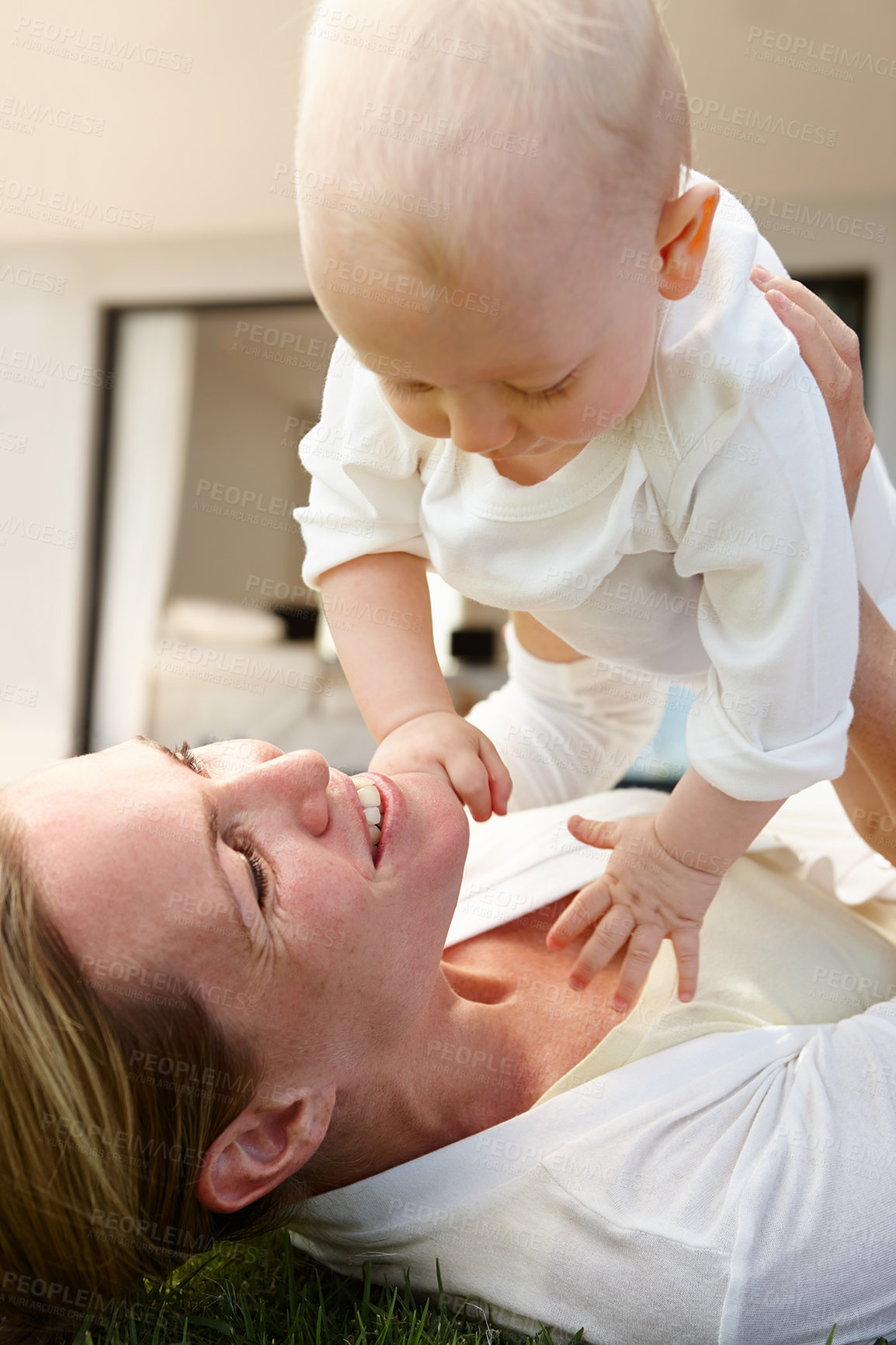 Buy stock photo Mother, baby and lifting with lying on grass for love, affection and child development for bonding. Mom, infant and raising with care, connection and smile with growth for happiness with memories