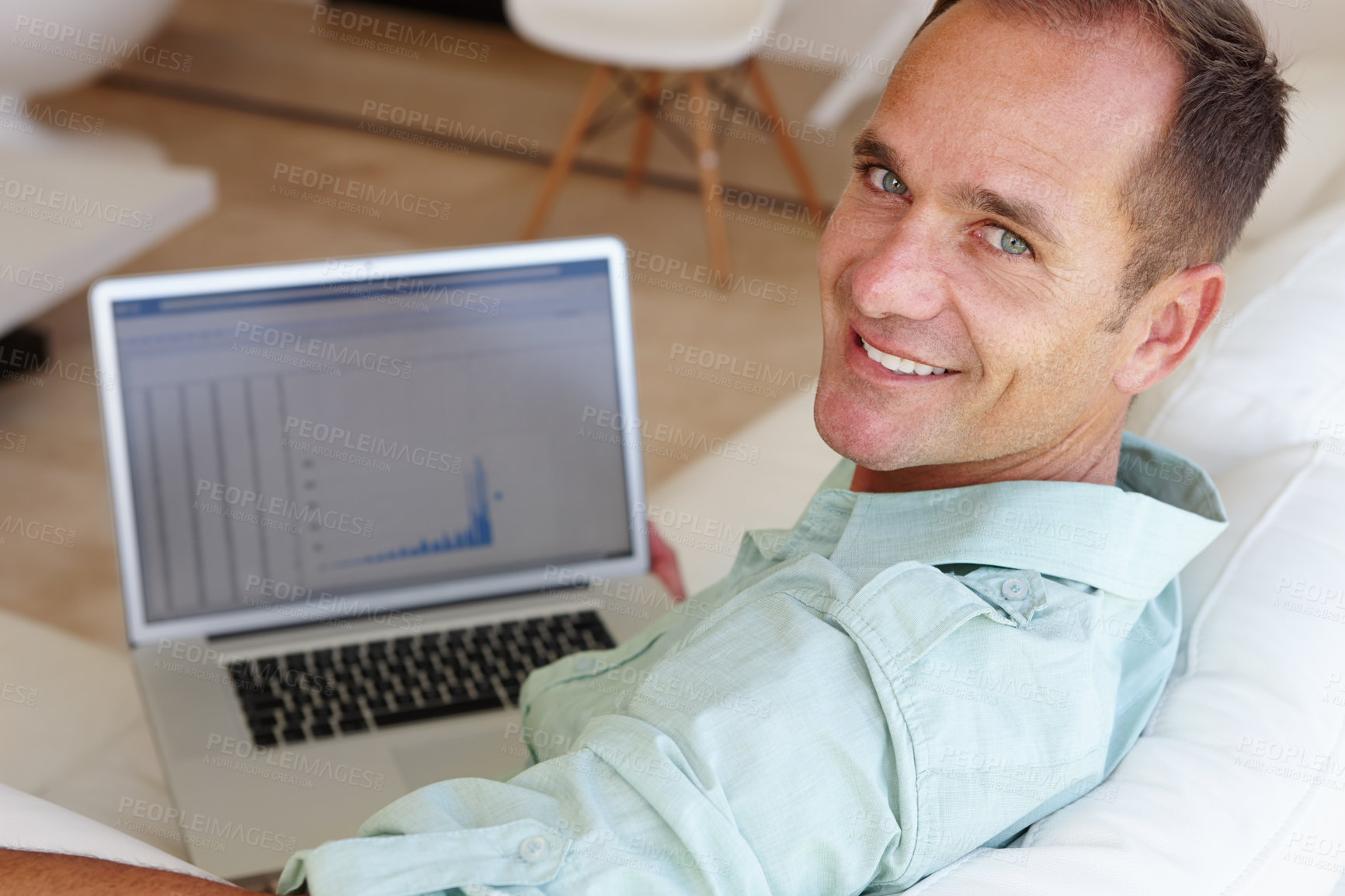 Buy stock photo Shot of an attractive mature man smiling at the camera while working on a report