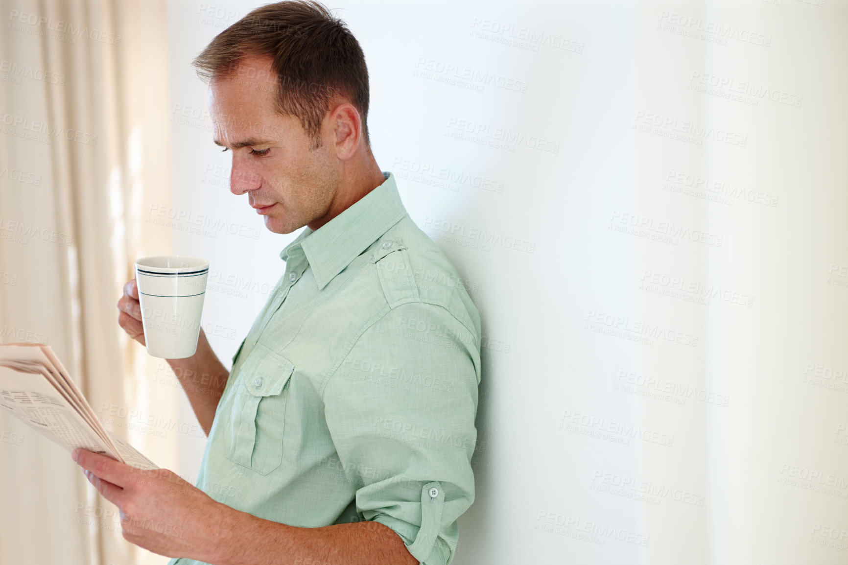 Buy stock photo Man, newspaper and reading with morning coffee, global news articles and headlines and checking stock information. Happy, smile male person and relax with beverage to drink, lounge in apartment