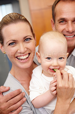 Buy stock photo Happy, family and portrait of people for love, affection and bonding at home, house and apartment together. Man, woman and baby with vegetable for eating, nutrition and wellness with embrace or hug