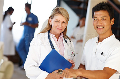 Buy stock photo Shot of two medical professionals smiling at the camera