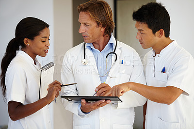 Buy stock photo Doctors, results and diversity with clipboard for evaluation, talking and health at hospital. Medical professionals, notes and people with decision in clinic for discuss, diagnosis and collaboration