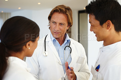 Buy stock photo Doctors, mentor and diversity with healthcare for discussion, talking and pen at hospital. Medical professionals, notepad and people with decision in clinic for medicine, results and collaboration