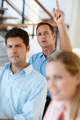 Buy stock photo Meeting, colleagues and man raise hand in office to ask questions or answer or ideas in workshop. Corporate, business people and male person with gesture in seminar or boardroom for feedback