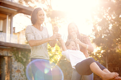 Buy stock photo Shot of a little girl playing outside with her mother and grandmother