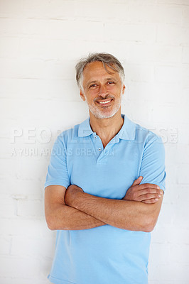 Buy stock photo Portrait, arms crossed and smile of mature man on brick wall for fashion isolated on white background in Switzerland. Face, confidence and happy person in casual clothes, shirt and positive for style