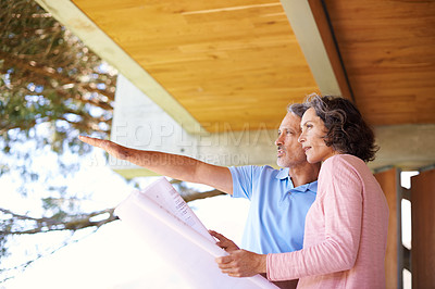 Buy stock photo Shot of a mature couple discussing blueprints