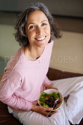 Buy stock photo Mature woman, couch and smile with salad or vegetables for diet, nutrition and health at home. Female person, sofa and happy in living room as vegetarian on break, relax and portrait from above