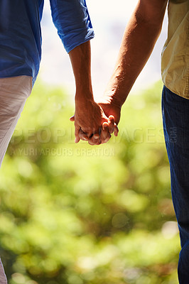 Buy stock photo Couple, holding hands and bonding together outdoor for romance and commitment in healthy relationship. People, love and holiday with touch for care, security and walking for date in countryside