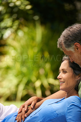 Buy stock photo A cropped shot of an affectionate mid adult couple sitting on the grass outdoors