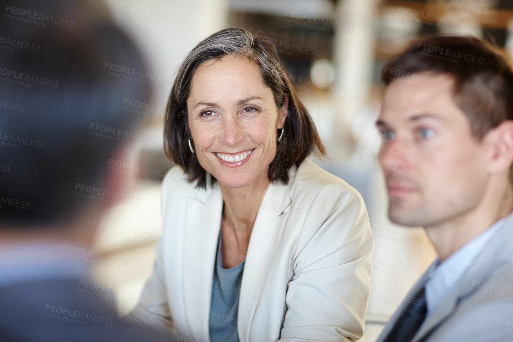 Buy stock photo A cropped shot of a happy businesswoman talking to colleagues at work