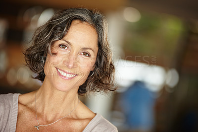 Buy stock photo A mature woman smiling happily while standing indoors at home