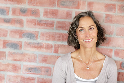 Buy stock photo A beautiful mature woman standing outdoors against a facebrick wall
