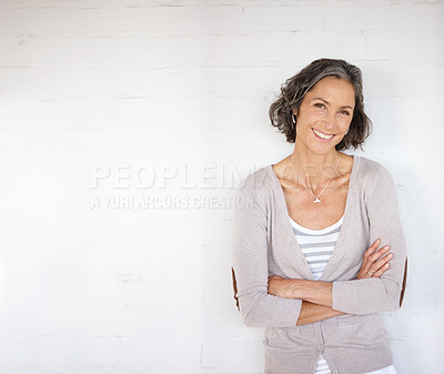 Buy stock photo Portrait of an attractive mature woman standing against a white wall