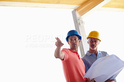 Buy stock photo Two architects assessing their building plans in an outdoor structure