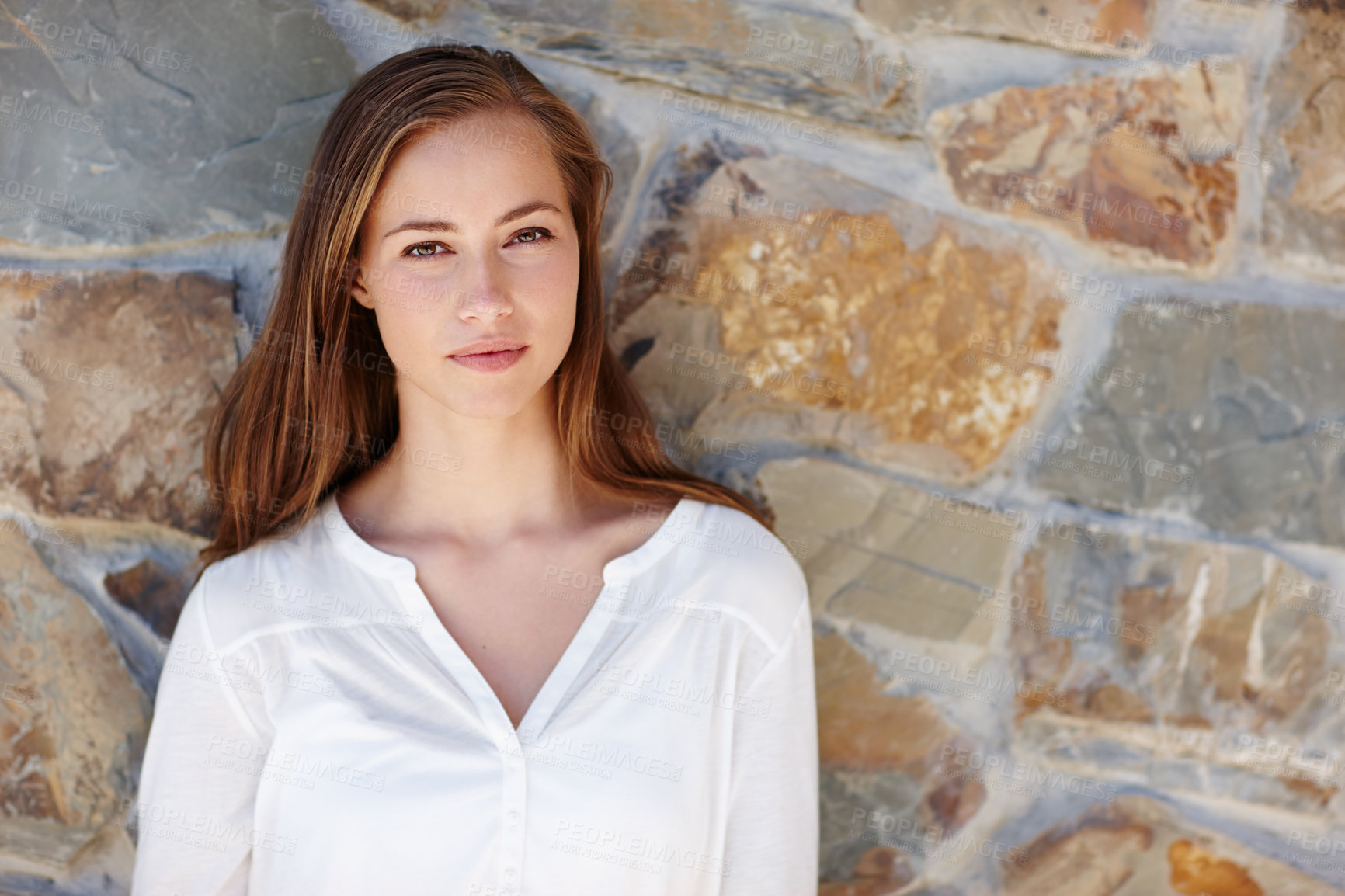 Buy stock photo Woman, portrait and relax by stone wall in home with confidence, pride and casual outfit on weekend. Person, face and smile for holiday, vacation or peaceful getaway with shirt, good mood and calm