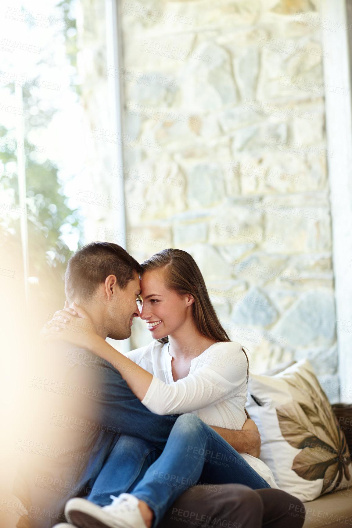 Buy stock photo Home, couple and forehead for romance, embrace and lap or care on couch in living room. Happy people, touch and smile for pride in relationship or commitment, loyalty and connection on hug date