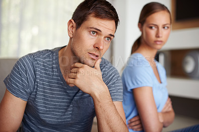 Buy stock photo Couple, disappointed and fight in home on sofa with stress or angry and sad with marriage issues. Relationship, confrontation and argument in living room on couch with conflict and emotional