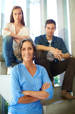 Buy stock photo Shot of a mother standing in front of her adult children on the stairs