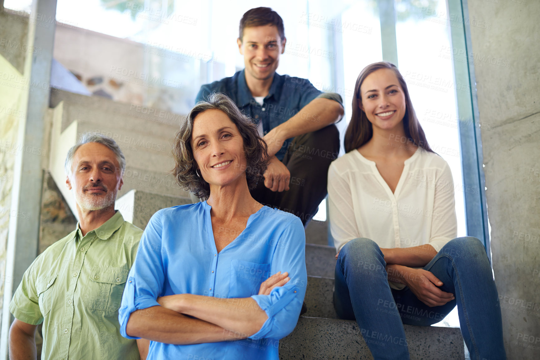 Buy stock photo Shot of a mother and father standing in front of their adult children on the stairs