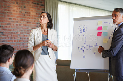 Buy stock photo Business presentation, teamwork or speaker by a board for teaching, advice tips or skill development in meeting. Mature, workshop or leaders talking in mentorship, training or coaching for learning